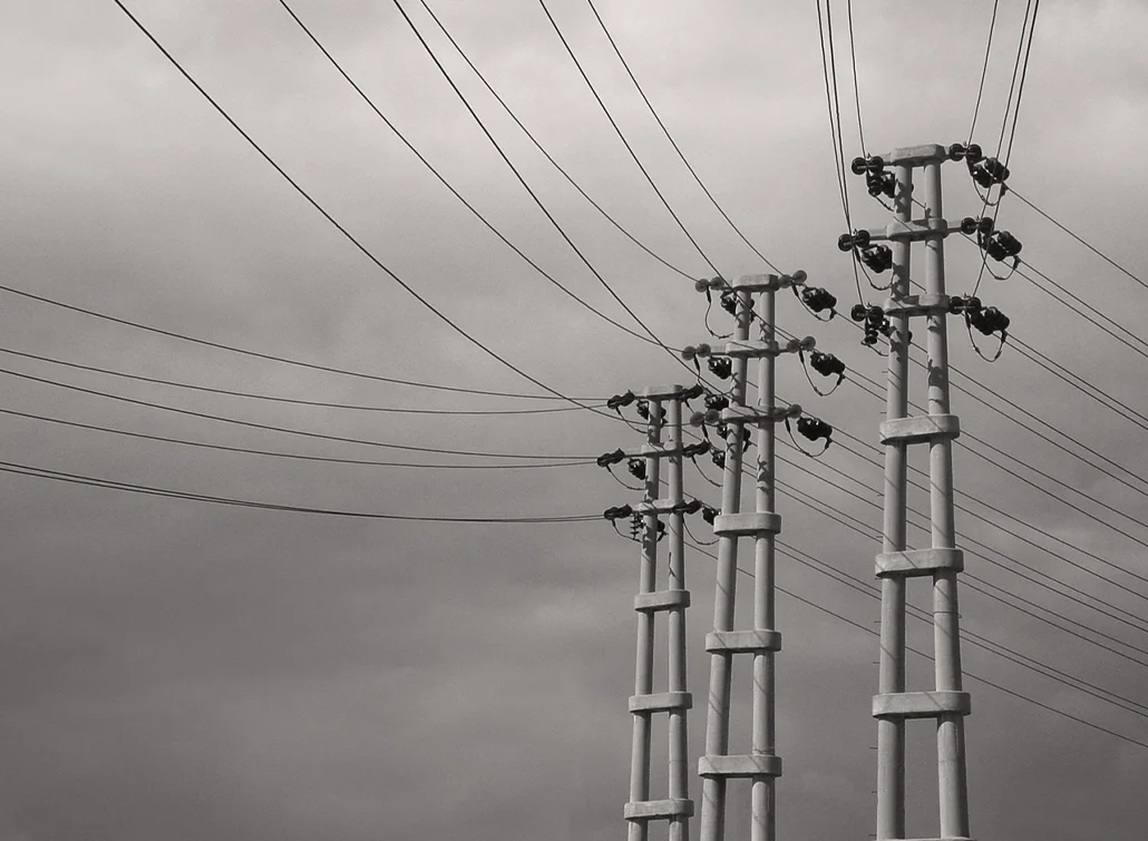 Tekrarlanan elektrik direği formları ve çizgisel kablolarla oluşturulmuş minimal ve zamansız sanat fotoğrafı.
