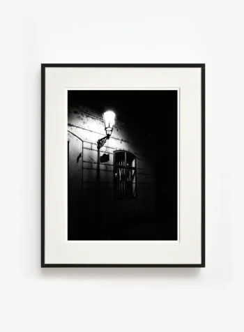 Sokak lambasının sınırlı ışığı, karanlığı yenemese de ona karşı durmayı seçen bir fotoğraf sanat eseri sunar.