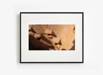 Gölgenin yüzey boyunca kıvrılması, mimari formu akışkan bir çizime dönüştüren fotoğraf sanat eseri.