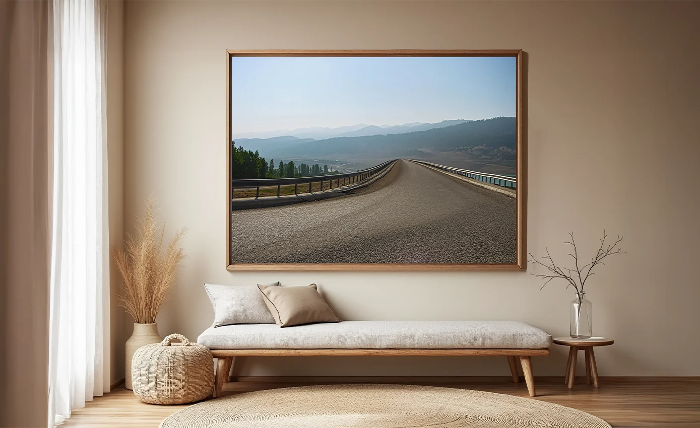 Açık gökyüzü altında uzanan asfalt yol ve arka plandaki dağları içeren fotoğraf temelli sanat eseri.